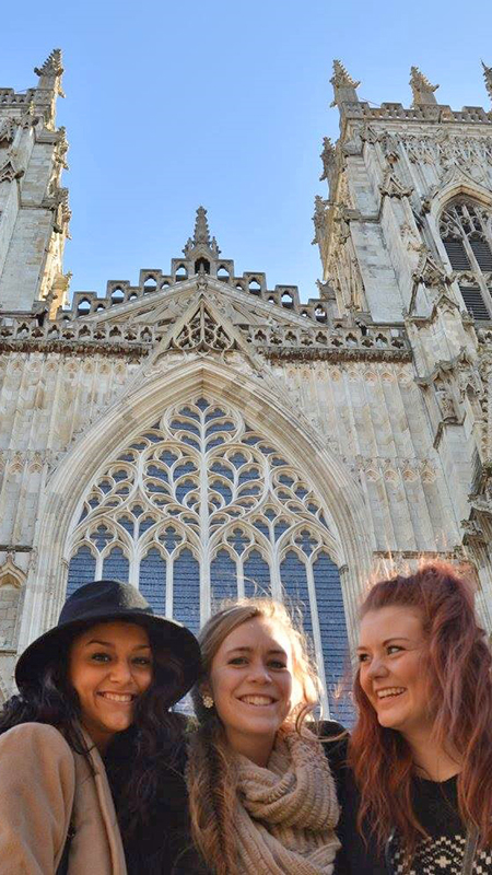 Student smiling in front of European cathedral