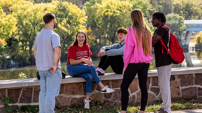 Group of students gathered around a seating area overlooking the Mississippi River